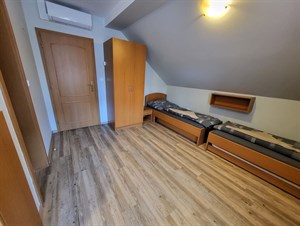 Čtyřlůžkový pokoj s šikmým stropem a dřevěnou podlahou