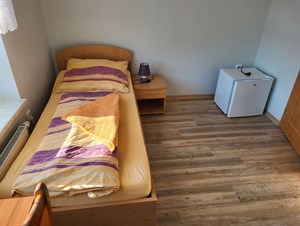 Dvoulůžkový pokoj s manželskou postelí a nočním stolkem